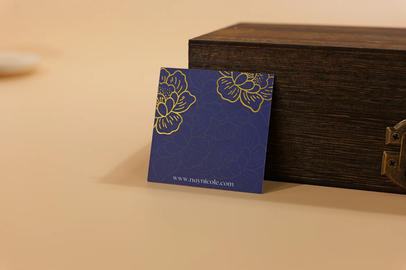 Printed blue brand card with gold floral artwork