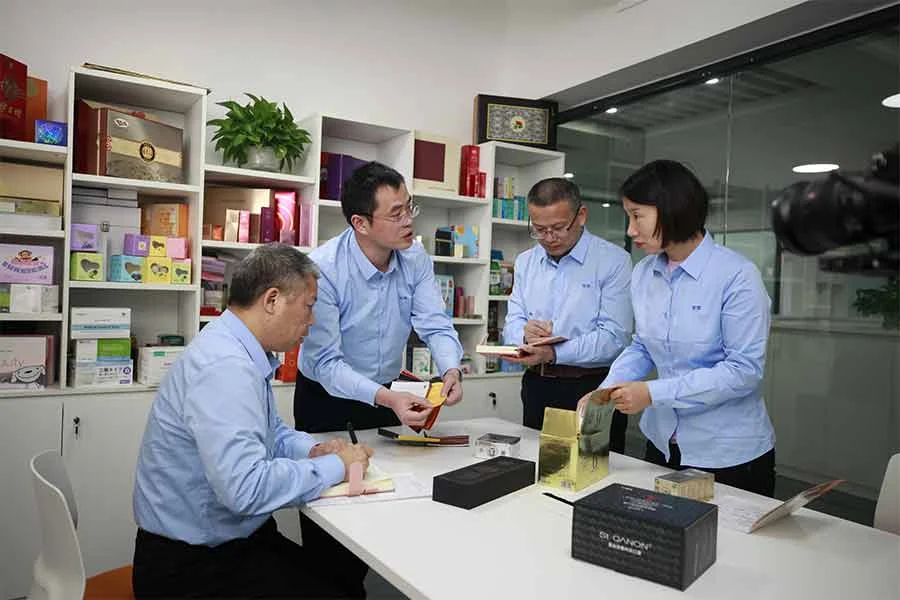 MEIKEI team reviewing printed packaging samples together