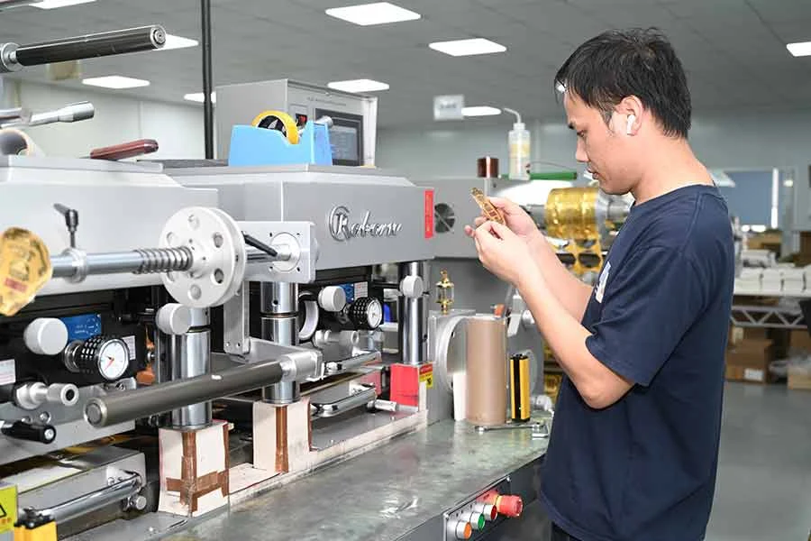 Operator inspecting a printed label beside the production equipment
