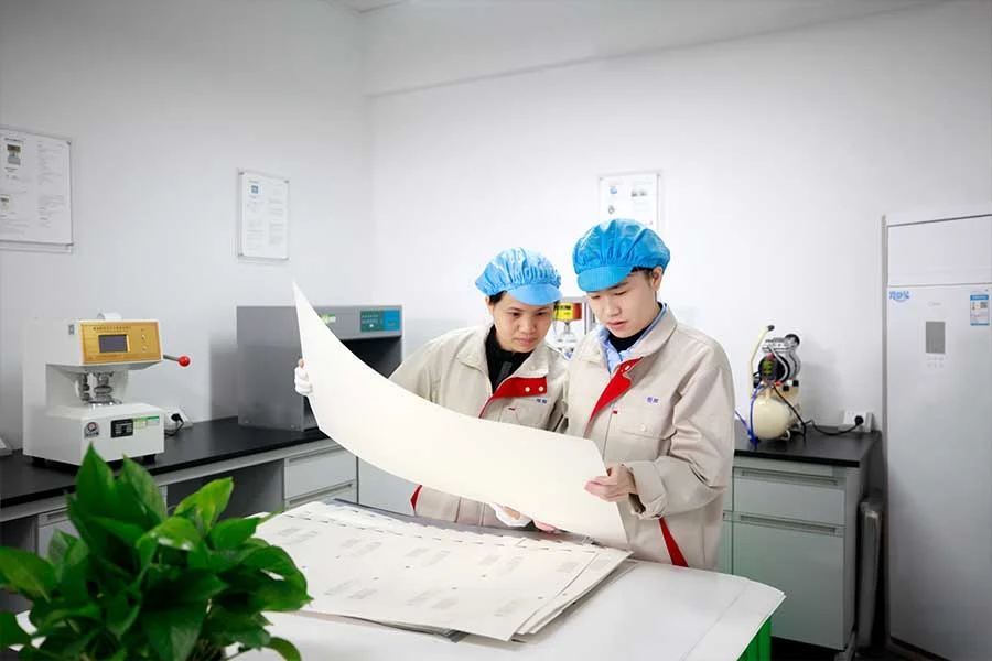 Two staff members examining a large paper sample together